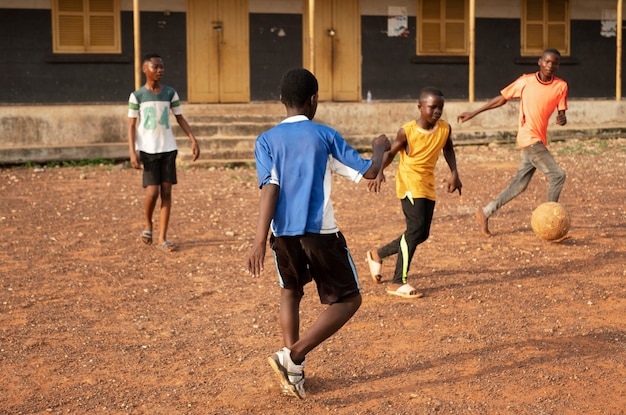 Bambini a tutto campo che giocano a calcio all'aperto
