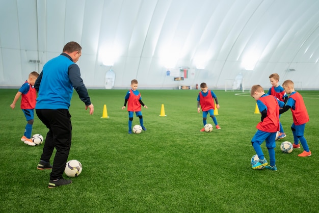 Bambini a tutto campo che giocano a calcio insieme