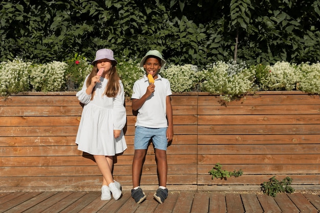 Bambini a tutto campo che mangiano il gelato