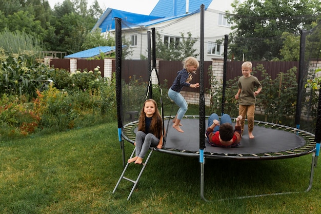 Bambini a tutto campo che saltano sul trampolino