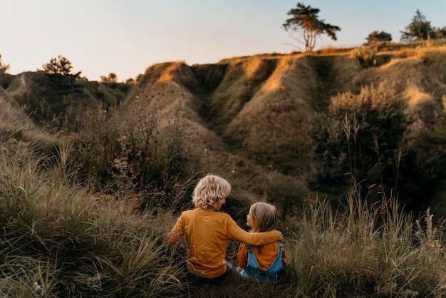 Bambini a tutto campo seduti sull'erba