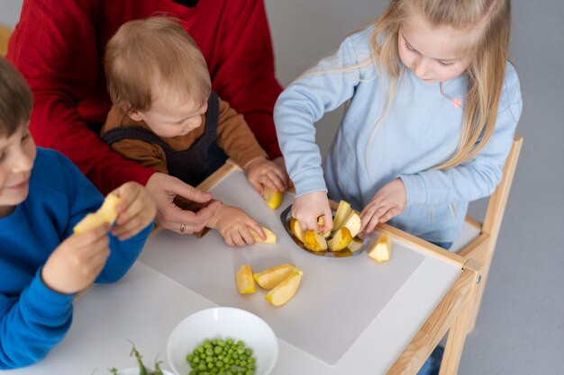 Bambini ad alto angolo con cibo sul tavolo