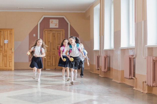 Bambini allegri che corrono nel corridoio della scuola