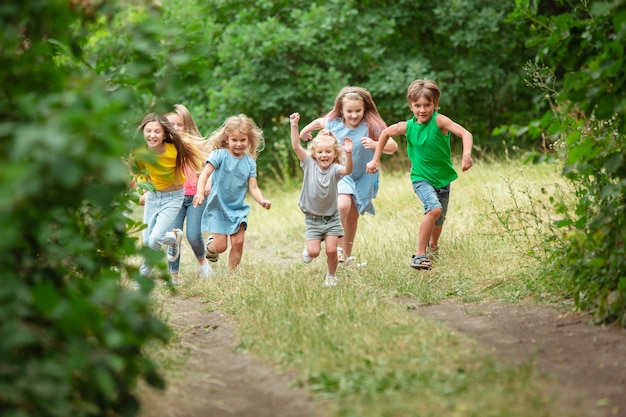 Bambini, bambini che corrono sul prato verde