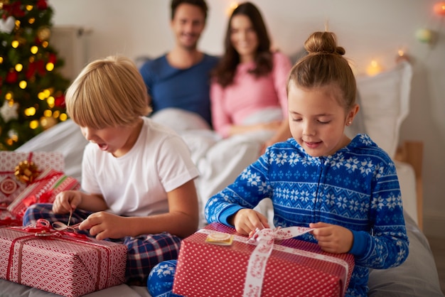 Bambini che aprono i regali di Natale al mattino