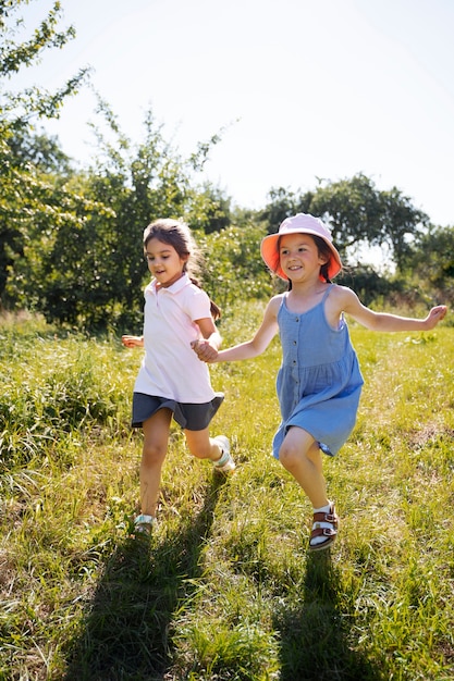 Bambini che corrono e giocano nel campo in erba all'aperto