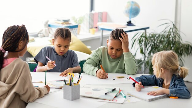 Bambini che disegnano insieme in classe