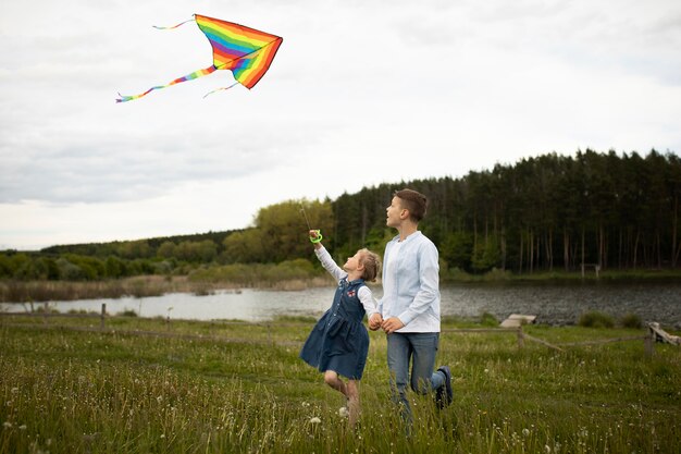 Bambini che fanno volare un aquilone a tutto campo