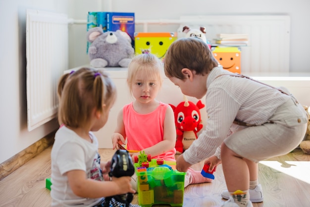 Bambini che giocano con i giocattoli sul pavimento