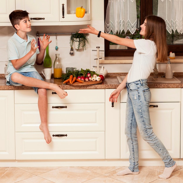 Bambini che giocano con la verdura in cucina