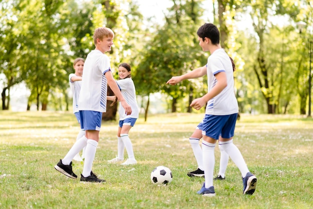 Bambini che giocano insieme a calcio