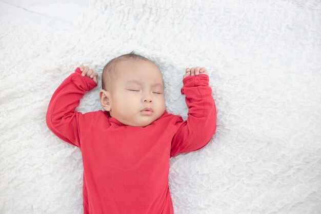 Bambini che indossano camicie rosse che dormono nel letto