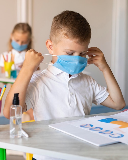 Bambini che indossano la sua maschera medica