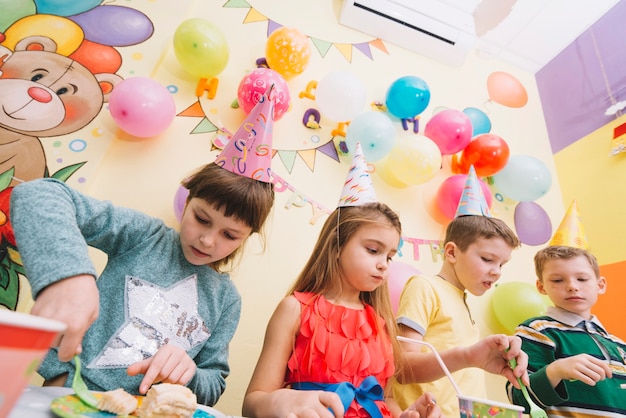 Bambini che mangiano durante la festa di compleanno