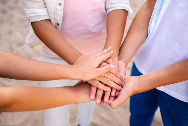 Bambini che mettono le mani uno sopra l'altro