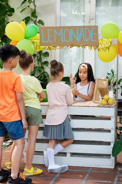 Bambini che organizzano un chiosco di limonate
