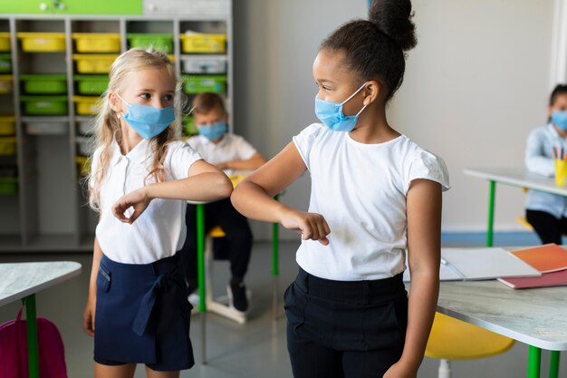 Bambini che sbattono il gomito in classe