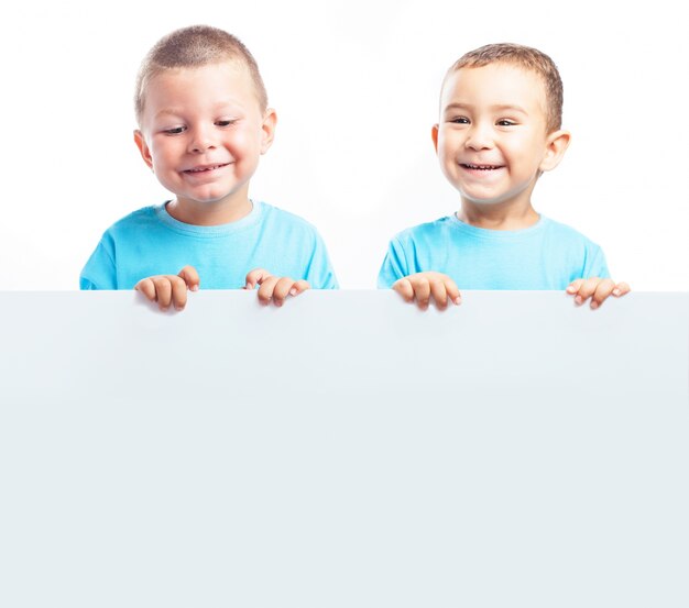 Bambini che tengono una bandiera in bianco mentre sorridendo