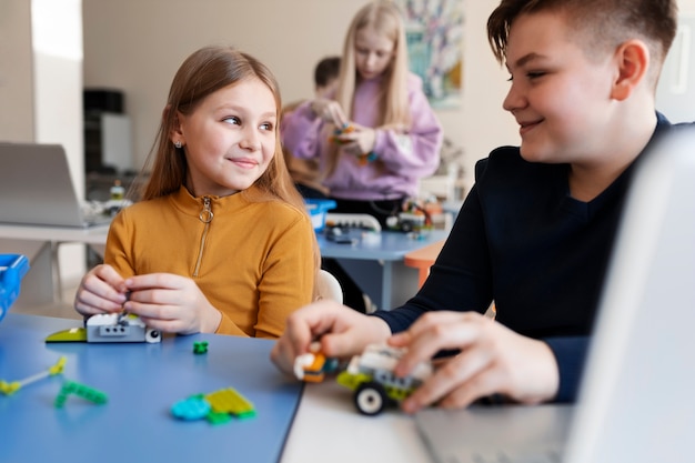 Bambini che usano parti elettroniche per costruire un robot