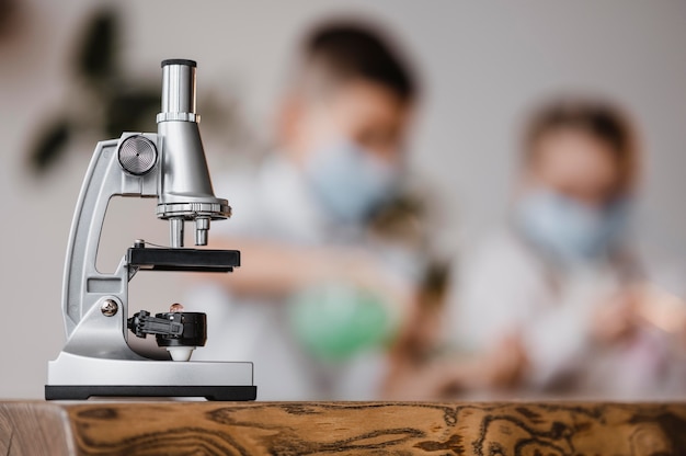 Bambini che usano un microscopio per imparare la scienza al chiuso