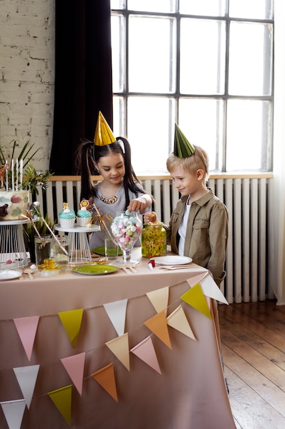 Bambini con vista laterale che indossano cappelli da festa