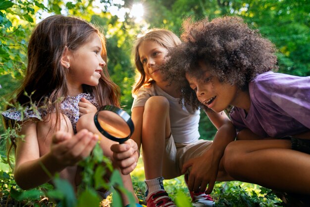 Bambini con vista laterale con lente d'ingrandimento