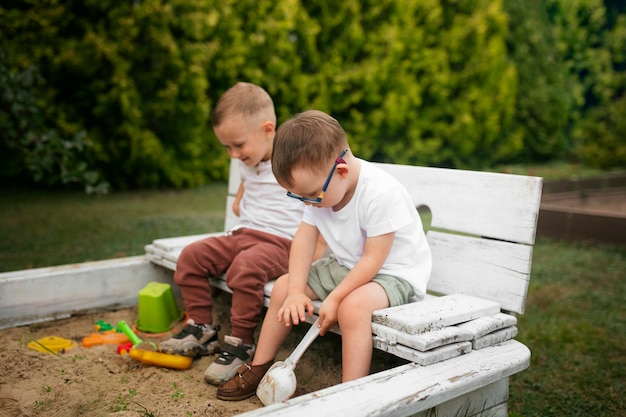 Bambini con vista laterale seduti fuori