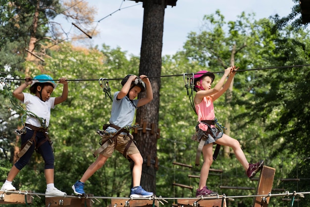 Bambini coraggiosi che giocano in un parco avventura