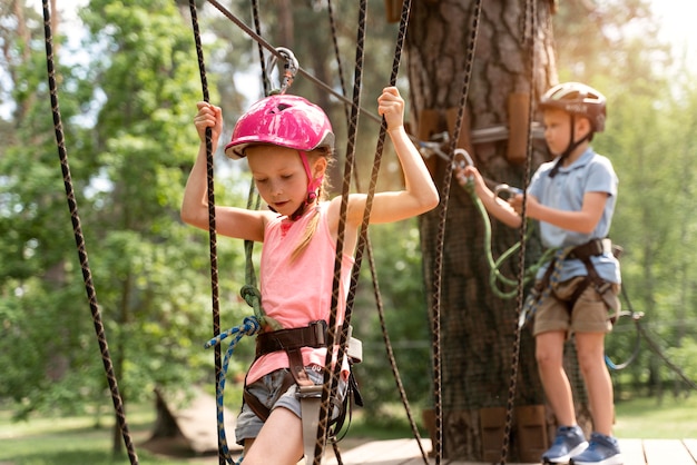 Bambini coraggiosi che si divertono in un parco avventura