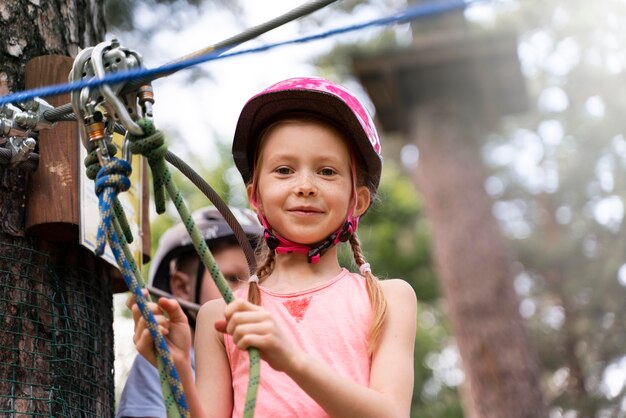 Bambini coraggiosi che si divertono in un parco avventura