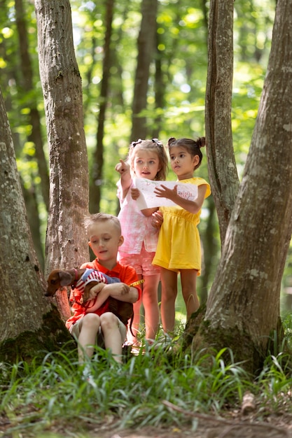 Bambini curiosi che partecipano a una caccia al tesoro nella foresta