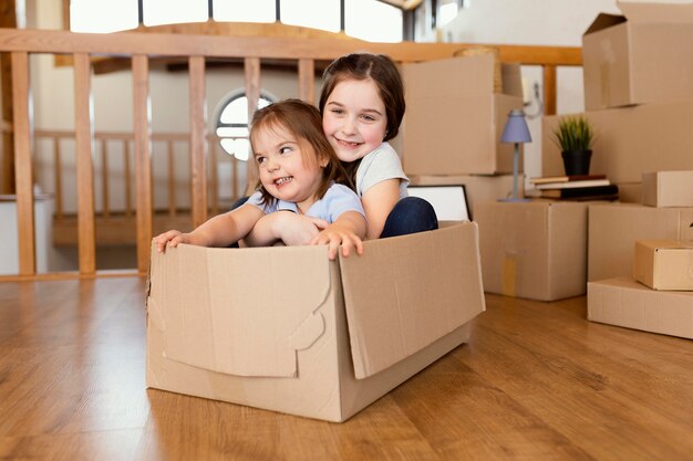 Bambini del colpo pieno che si siedono nella scatola