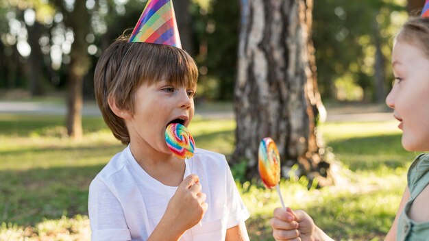 Bambini del primo piano che mangiano i lecca-lecca