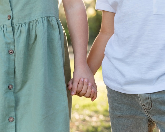 Bambini del primo piano che tengono le mani