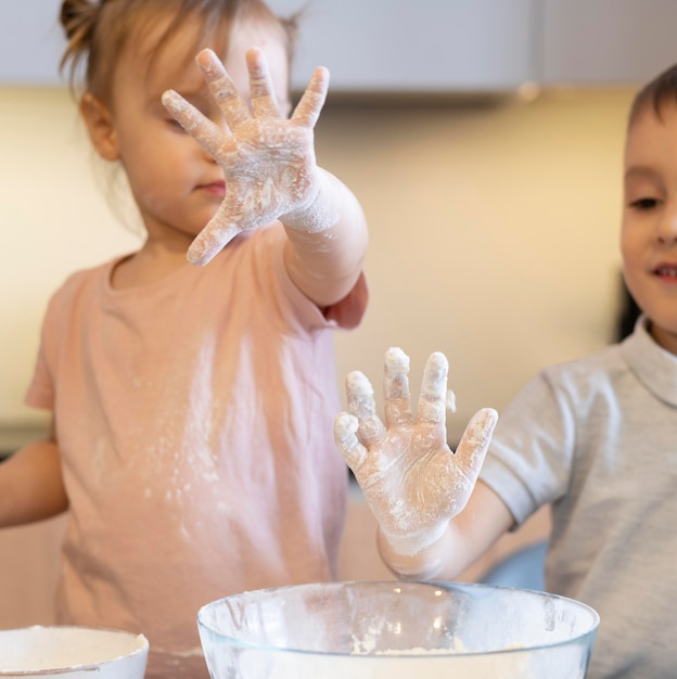 Bambini del primo piano con farina sulle mani