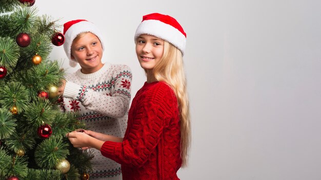 Bambini di Natale che decorano l'albero