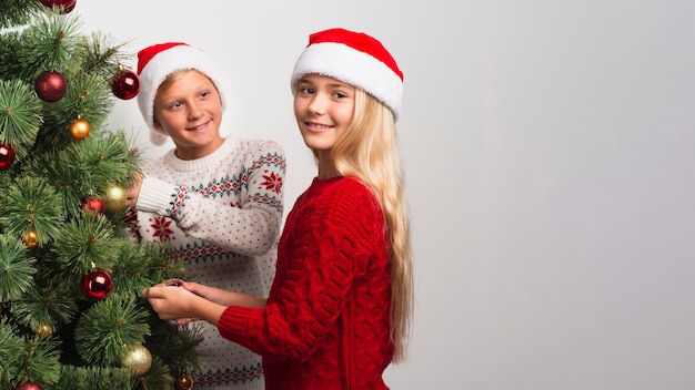 Bambini di Natale che decorano l'albero