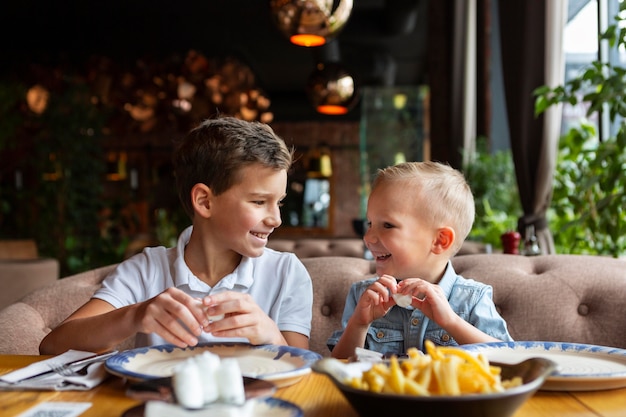 Bambini di tiro medio che mangiano fast food