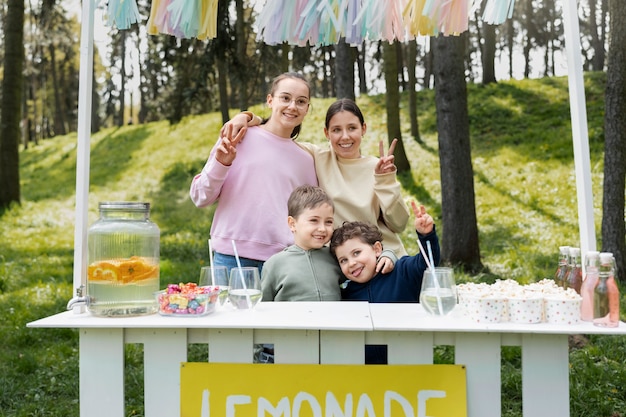 Bambini di tiro medio con bancarella di limonata