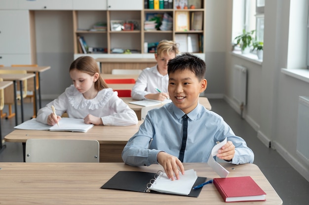 Bambini di tiro medio seduti a scuola