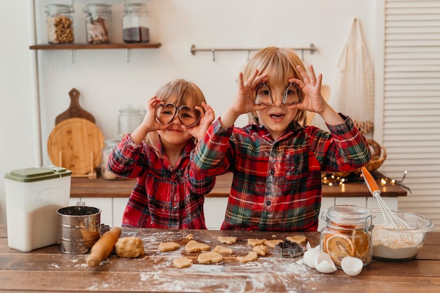 Bambini di vista frontale che fanno i biscotti insieme a casa