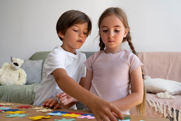 Bambini di vista frontale che fanno insieme puzzle