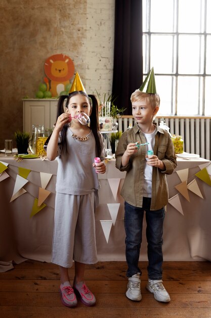 Bambini di vista frontale che fanno le bolle di sapone