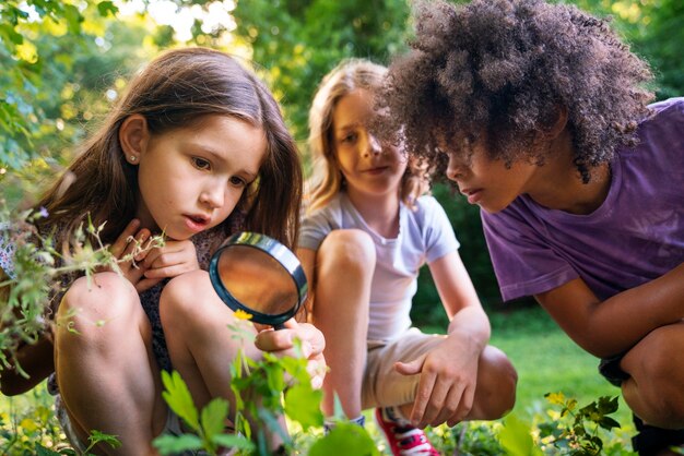 Bambini di vista frontale con la lente d'ingrandimento