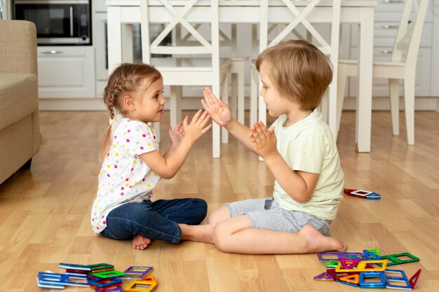 Bambini di vista laterale a casa che giocano con i giocattoli