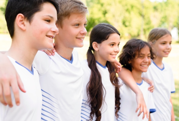 Bambini di vista laterale in abiti sportivi che si tengono l'un l'altro