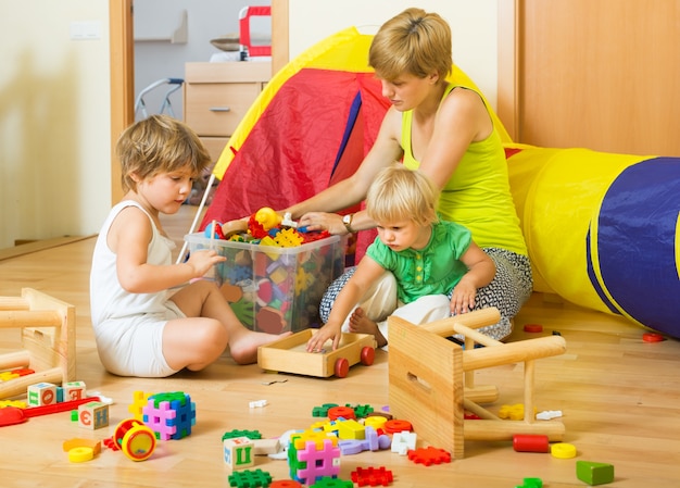 Bambini e madre che collezionano giocattoli