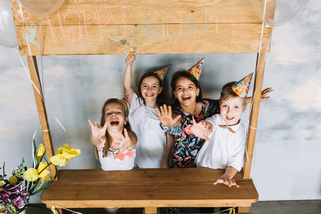 Bambini eccitati che allungano le braccia sulla festa di compleanno