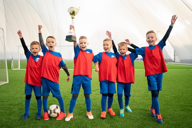 Bambini felici a tutto campo con trofeo