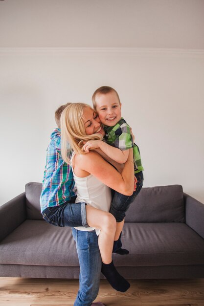 Bambini felici che abbracciano la madre